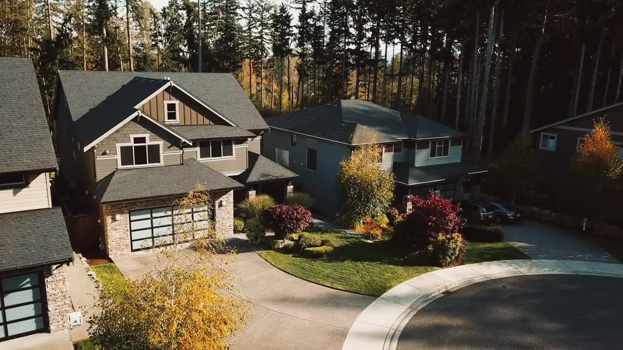 Aerial view of a house on a treed lot in autumn